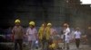 Migrant construction workers walk out of a residential construction site after their shifts in Shanghai July 2, 2013. The construction site is amidst a new developing residential area located in Jiading district of suburban Shanghai, some 30 kilometres (1