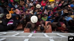 FILE - Villagers place the remains of their recently identified relatives killed during the civil war, in niche graves at the cemetery of Santa Avelina, Guatemala, Nov. 30, 2017.