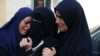 Palestinian women react upon identifying the bodies of victims of an Israeli strike that targeted a mosque-turned-shelter in Deir al-Balah in the central Gaza Strip, in the courtyard of the al-Aqsa Martyrs hospital on Oct. 6, 2024.