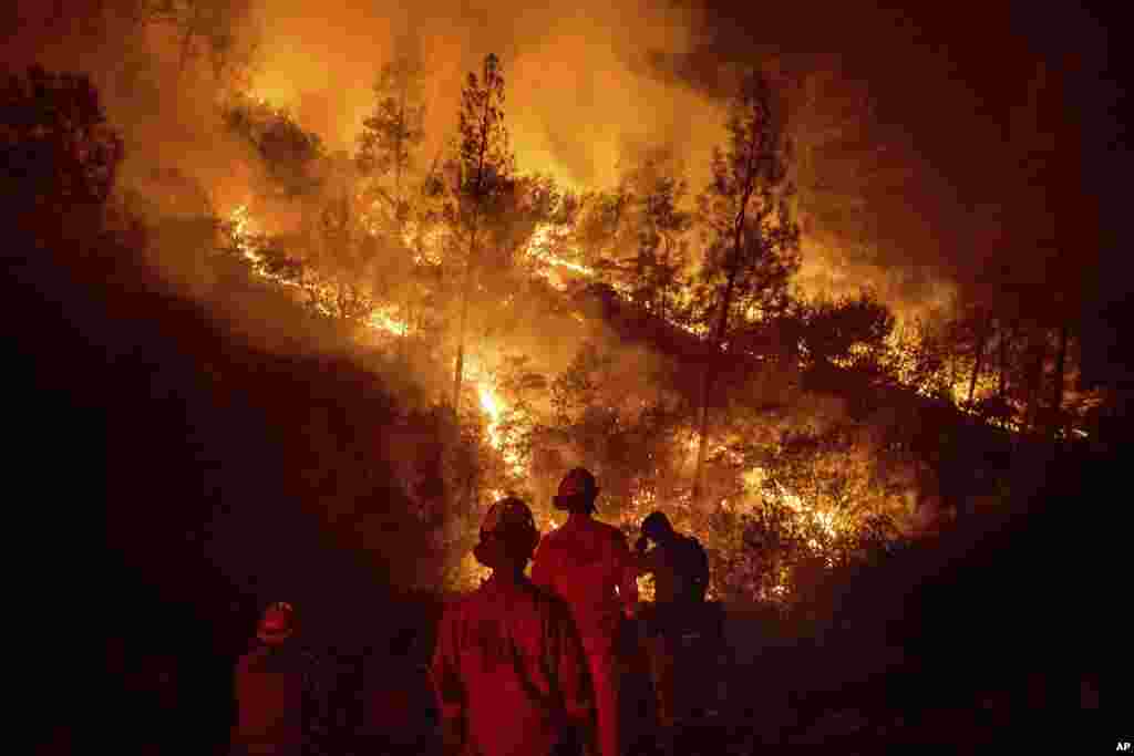 Firefighters monitor a backfire while battling the Ranch Fire, part of the Mendocino Complex Fire near Ladoga, California.