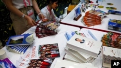 FILE - Copies of the book on the governance of Chinese President Xi Jinping are displayed with booklets promoting Xinjiang during a press conference, July 30, 2019.