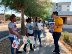 FILE - From left, Tameka Spence, Shelley Jackson, Karen Hernandez and Francisco Lopez talk following a demonstration where they and others voiced their opposition to a local city initiative, Aug. 20, 2019.