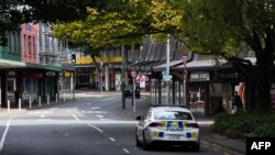 Sebuah mobil polisi berpatroli di jalan-jalan di kawasan pusat bisnis yang biasanya sibuk setelah lockdown level 4 diberlakukan, di Wellington pada 26 Maret 2020. (Foto: AP)