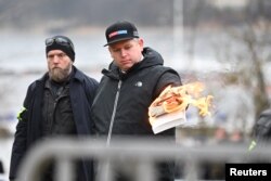 Pemimpin Partai ekstrem kanan asal Denmark, Rasmus Paludan, membakar Al-Qur'an di luar Kedutaan Besar Turki di Stockholm, Swedia, Sabtu, 21 Januari 2023. (Foto: Fredrik Sandberg/TT News Agency/via REUTERS)