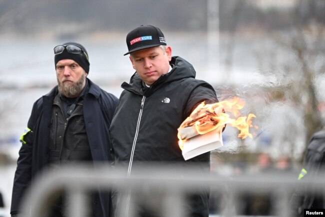 Pemimpin Partai ekstrem kanan asal Denmark, Rasmus Paludan, membakar Al-Qur'an di luar Kedutaan Besar Turki di Stockholm, Swedia, Sabtu, 21 Januari 2023. (Foto: Fredrik Sandberg/TT News Agency/via REUTERS)