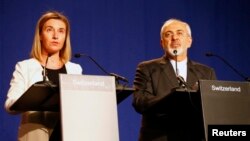 Kepala kebijakan LN Uni Eropa, Federica Mogherini (kiri) dan Menlu Iran, Javad Zarif memberikan keterangan pers mengenai perundingan nuklir Iran di Lausanne, Swiss (2/4).