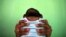 FILE - Jackeline, 26, holds her son who is 4-months old and born with microcephaly, in front of their house in Olinda, near Recife, Brazil, February 11, 2016.