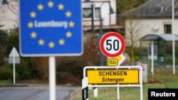 FILE -- A street sign marks the beginning of Schengen, Luxembourg. Schengen Agreement with the goal to illiminate internal border controls was signed there June 14, 1985. The European Union says it won't extend the temporary border controls beyond November. 