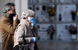 Relatives attend the funeral of a woman who died from the coronavirus disease, as Italy struggles to contain the spread of COVID-19 in Seriate, March 28, 2020.