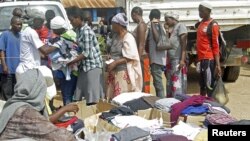 Families queue at a United Nations Human Rights Council (UNHRC) centre for Burundi refugees in Uvira to receive food ration and clothing in South Kivu in the Democratic Republic of Congo (DRC) May 20, 2015.