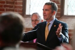 Virginia Gov. Ralph Northam addresses a meeting of the Virginia General Assembly on the 400th anniversary of the first House of Burgess meeting at a church in Historic Jamestown, Va., on the site where the meeting took place, July 30, 2019.