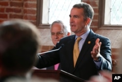 Virginia Gov. Ralph Northam addresses a meeting of the Virginia General Assembly on the 400th anniversary of the first House of Burgess meeting at a church in Historic Jamestown, Va., on the site where the meeting took place, July 30, 2019.