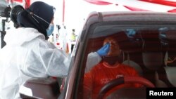 Petugas kesehatan melakukan tes swab kepada pengemudi mobil di Cikarang, Bekasi saat warga kembali ke Jakarta pasca Idul Fitri lalu (foto: dok). 