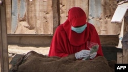 Une vendeuse de Khat porte un masque et des gants pour empêcher la propagation du coronavirus à Djibouti, le 26 mars 2020.