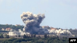 Une épaisse fumée s'élève suite à une frappe israélienne dans le village libanais de Tayr Harfa, près de la frontière israélo-libanaise, le 23 septembre 2024. AFP / Kawnat Haju