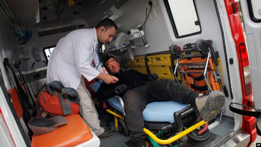 Seorang dokter Nepal memeriksa pendaki gunung asal China, Liu Lei, setelah ia berhasil mencapai puncak Gunung Everest, saat ia tiba di bandar udara Kathmandu, Nepal (24/5). (AP/Niranjan Shrestha)