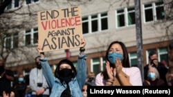 Dawn Cheung dan Victoria Do bertepuk tangan saat memprotes kejahatan kebencian anti-Asia, Washington, A.S. 13 Maret 2021. (Foto: REUTERS/Lindsey Wasson)