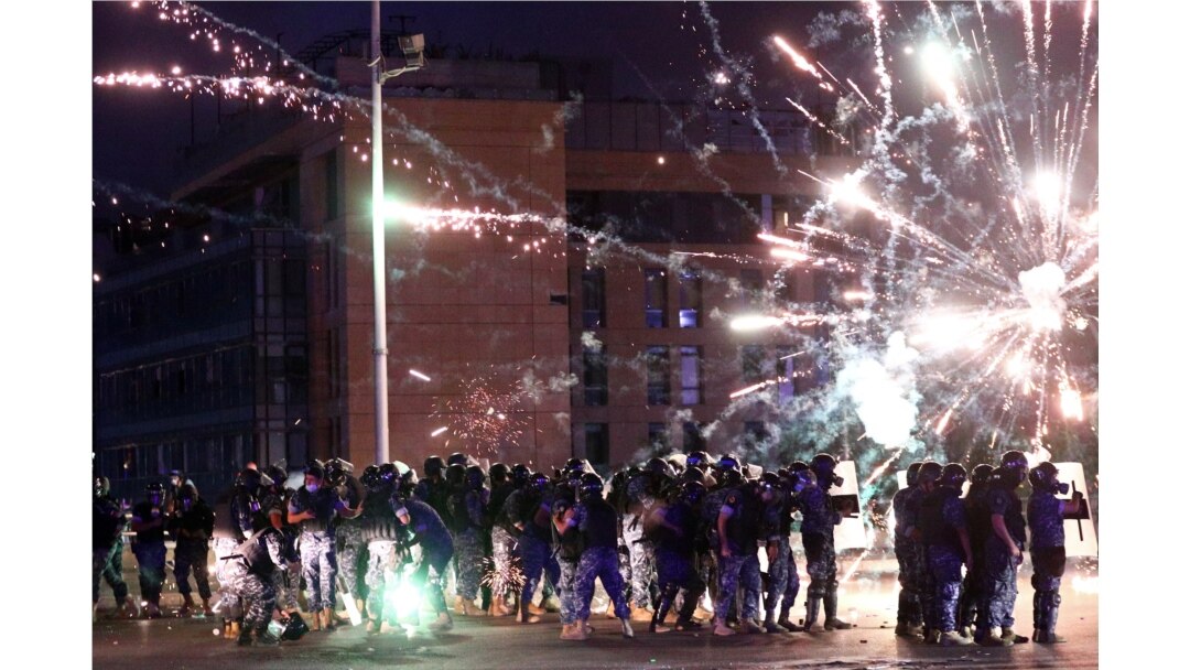 Fireworks are set off in front of police officers during anti-government protests that have been ignited by a massive explosion in Beirut, Lebanon, Aug. 10, 2020.