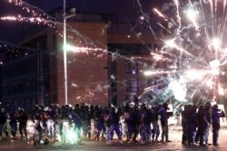 Fireworks are set off in front of police officers during anti-government protests that have been ignited by a massive explosion in Beirut, Lebanon, Aug. 10, 2020.