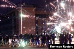 Fireworks are set off in front of police officers during anti-government protests that have been ignited by a massive explosion in Beirut, Lebanon, Aug. 10, 2020.