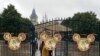 Employees stand at the gates of the Shanghai Disney Resort, which announced that it will be closed indefinitely from Saturday, in Shanghai, Jan. 25, 2020.