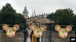 Employees stand at the gates of the Shanghai Disney Resort, which announced that it will be closed indefinitely from Saturday, in Shanghai, Jan. 25, 2020.