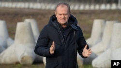 FILE - Poland's Prime Minister Donald Tusk speaks to reporters in Dabrowka, Poland, during a visit to Poland's border with Russia, Nov. 30, 2024. On Tuesday, he said peace talks for the war in Ukraine could begin in the winter.