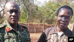 FILE - In this photo released by the Uganda People's Defense Force (UPDF), Ugandan Contingent Commander to the African Union Regional Task Force Col Michael Kabango, left, talks with a man in UPDF custody said by the UPDF to be the wanted Lord's Resistance Army (LRA) commander Dominic Ongwen, right, in the Central African Republic. 