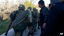 Belbek လေတပ်အခြေစိုက်စခန်းကို သိမ်းပိုက်ဖို့ ချီတက်လာကြတဲ့ ရုရှားစစ်သားတွေနဲ့ ရုရှားလိုလားသူများ။ (မတ် ၂၂၊ ၂၀၁၄)