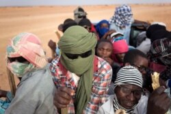 FILE - Nigeriens and third-country migrants head into the Sahara Desert towards Libya from Agadez, Niger, June 4, 2018.