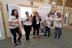 FILE - In this Dec. 10, 2019 photo, members of the Hispanic Federation celebrate after officially opening their first field office in Davenport, Fla. The group is helping register Hispanic residents to vote in upcoming elections.
