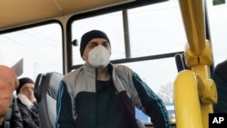 Separatist war prisoners, some of them wearing face masks to protect against coronavirus, sit in a bus after they were exchanged near the checkpoint Horlivka, eastern Ukraine, April 16, 2020.