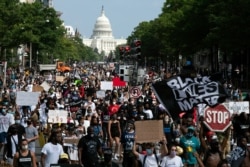 People walk on Pennsylvania Avenue during the March on Washington, Aug. 28, 2020, on the 57th anniversary of Martin Luther King Jr.'s 'I Have A Dream' speech.