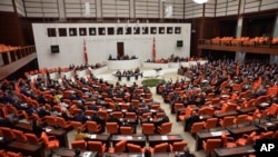 Lawmakers debate before Turkey's parliament to approve a motion that gives the government new powers to launch military incursions into Syria and Iraq and to allow foreign forces to use its territory for possible operations against the Islamic State group