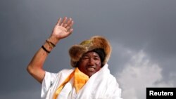 FILE - Kami Rita Sherpa, a Nepali mountaineer, waves toward the media in Kathmandu, Nepal, May 20, 2018.