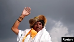 FILE - Kami Rita Sherpa, a Nepali mountaineer, waves toward the media in Kathmandu, Nepal, May 20, 2018.