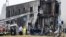 Fire fighters and police officers work at the scene where a small plane crashed into a building in San Donato Milanese, Italy, Oct. 3, 2021. 