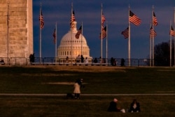 FILE - The US Capitol Building is seen past the Washington Monument as the sun sets on December 26, 2020 in Washington, DC. Lawmakers will meet on Jan. 6 to confirm the presidential election results.