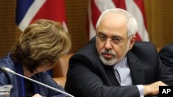 European foreign policy chief Catherine, Ashton, left, and Iranian Foreign Minister Mohammad Javad Zarif, right, wait for the start of closed-door nuclear talks in Vienna, Austria, Tuesday, June 17, 2014