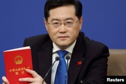 Menteri Luar Negeri China Qin Gang memegang buku Konstitusi China pada konferensi pers di sela-sela Kongres Rakyat Nasional (NPC) di Beijing, China, 7 Maret 2023. (Foto: REUTERS/Thomas Peter)