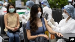 Health workers administer shots of the Sinovac COVID-19 vaccine for airline employees at Siam Paragon shopping mall in Bangkok, Thailand, Tuesday, May 25, 2021. (AP Photo/Sakchai Lalit)