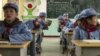 Children dressed in uniform gather in their classroom at the Beichuan Red army elementary school in Beichuan, southwest China's Sichuan province, To go with AFP story China-politics-education-history, Jan. 21, 2015.