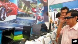 A customer (R) wears 3D glasses as he views a 3D movie on a Toshiba computer during an exhibition in Phnom Penh, Cambodia on September 11, 2010