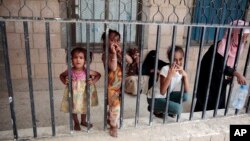 Displaced Yemeni girls and their families, who fled their homes by the fighting the port city of Hodeida, are seen in a school allocated for IDPs in Sanaa, Yemen, Saturday, Jun. 23, 2018.