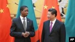 FILE - Chinese President Xi Jinping, right, talks with Zambia's President Edgar Chagwa Lungu, during a signing ceremony at the Great Hall of the People Monday, March 30, 2015 in Beijing, China. 