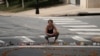 A woman kneels at a makeshift memorial for the victims of a car that plowed into counter-protesters after a "Unite the Right" rally organized by white nationalists in Charlottesville, Virginia, Aug. 13, 2017. 