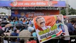 Supporter of Sri Lankan president Maithripala Sirisena and his newly appointed prime minister Mahinda Rajapaksa attend a rally held out side the parliamentary complex as police officer tries to control the crowd in Colombo, Sri Lanka, Nov. 5, 2018.