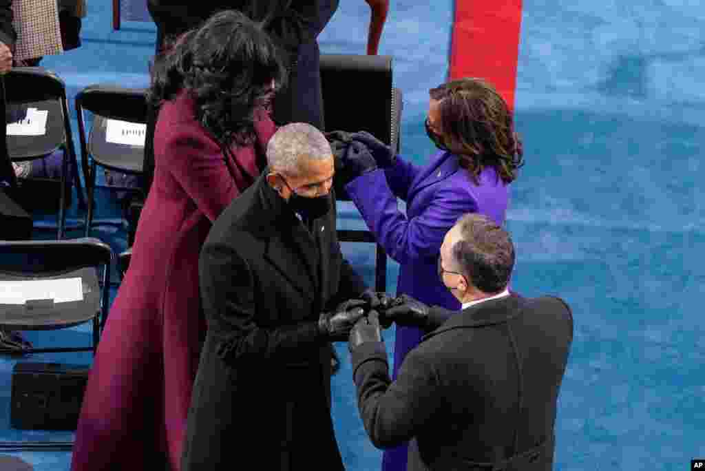 Vice President-elect Kamala Harris and her husband Doug Emhoff are greeted by former President Barrack Obama and Michelle Obama, during the 59th Presidential Inauguration at the Capitol in Washington.