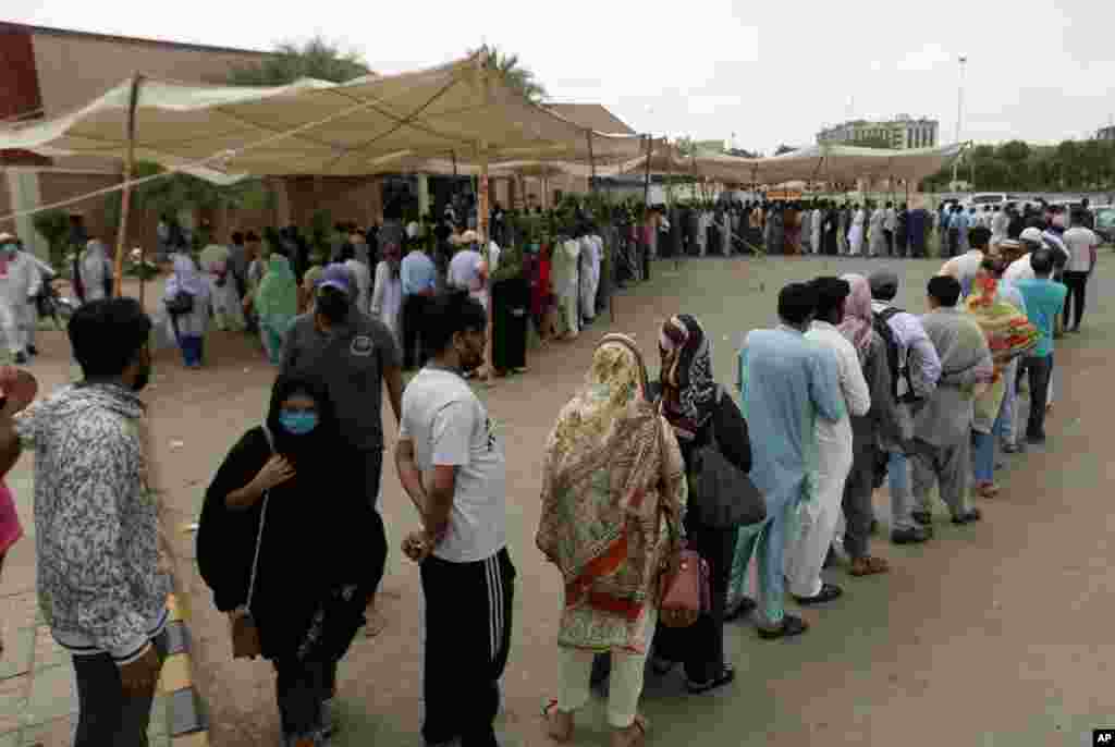 صف مردم برای دریافت واکسن کووید-۱۹ در یک مرکز واکسیناسیون در کراچی، پاکستان