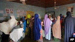 FILE - FILE - Women gather at a clinic to have their children vaccinated in Niamey, Niger, Aug. 21, 2023. Families in Niger say they are struggling in the wake of economic sanctions imposed after a military coup. 